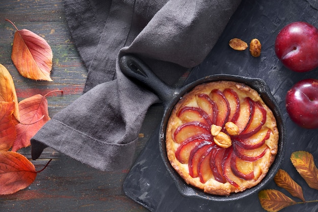 Crostata fatta in casa con fette di prugne cotte in padella di ferro