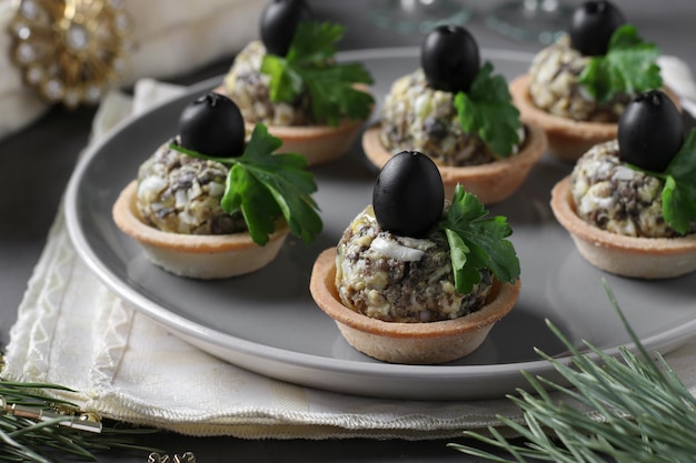 Crostatine con uova di funghi e olive nere su sfondo grigio scuro Primo piano