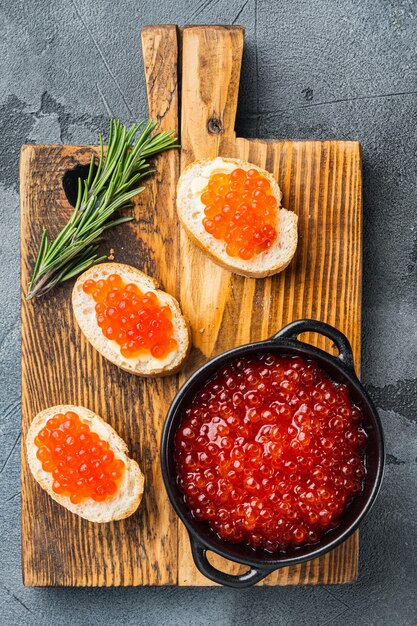 Crostini con caviale rosso, su sfondo grigio, vista dall'alto piatta