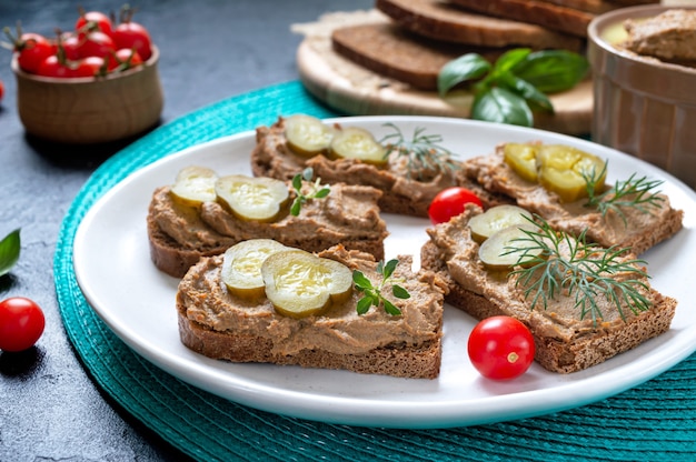 Crostini con patè di fegato di pollo e cetrioli sottaceto su pane di segale. Antipasto gustoso e salutare