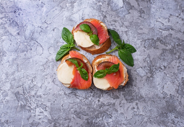 Crostini con salmone, mozzarella, pomodoro e basilico