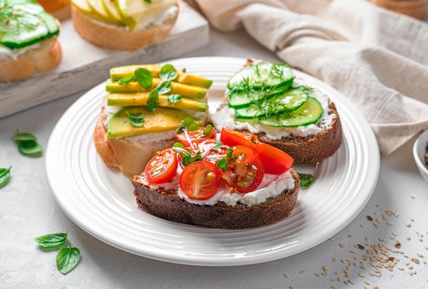 Crostini su pane di segale e grano con feta verdure frutta ed erbe fresche Vista laterale Cibo sano