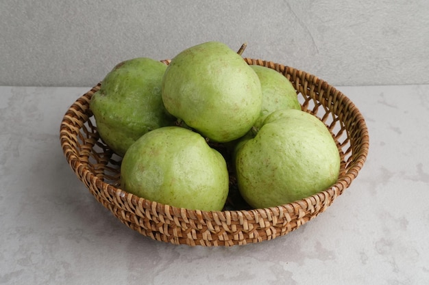 Crystal Guava Psidium guajava o Jambu Kristal servito in cesto di rattan su sfondo grigio