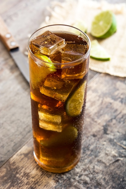 Cuba libre Cocktail con rum, lime e ghiaccio sul tavolo di legno