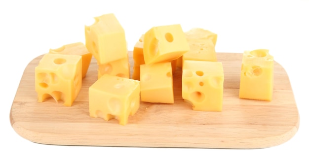 Cubetti di formaggio su tavola di legno isolati su bianco