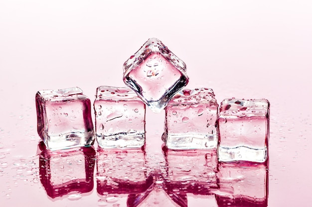Cubetti di ghiaccio sulla superficie rosa