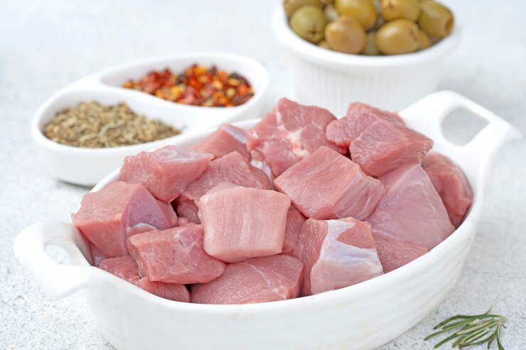 Cubetti di pollo crudo su un piatto bianco