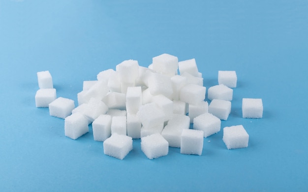 Cubetti di zucchero bianco su sfondo blu