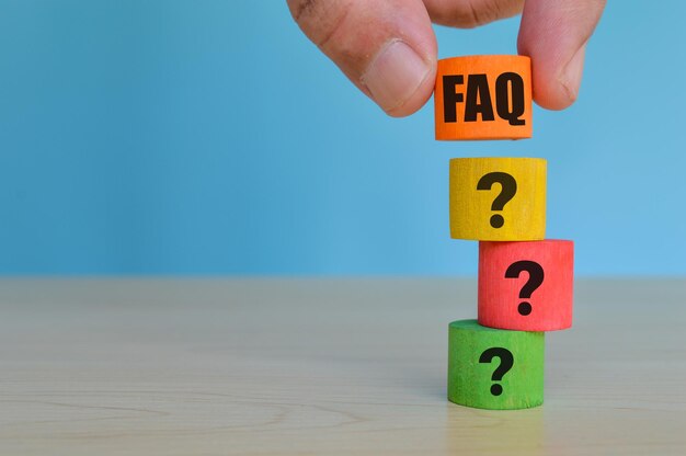 Cubi colorati in legno con testo FAQ e punti interrogativi