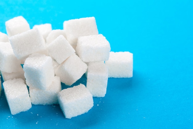 Cubi dello zucchero bianco su un blu luminoso