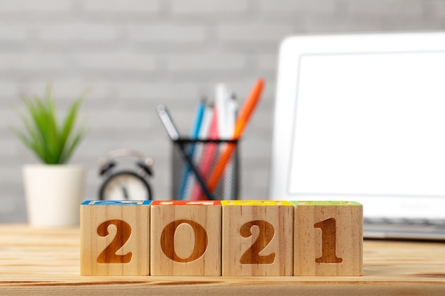 Cubi di legno 2021 anni sul tavolo di lavoro con laptop aperto.