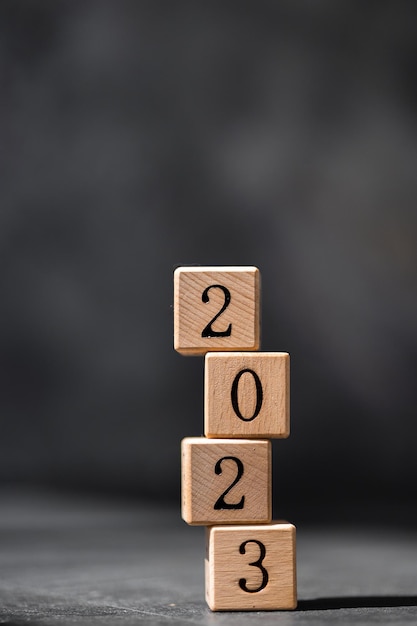 Cubi di legno geometrici sul tavolo con i numeri 2023 Concetto di nuovo anno 2023 spazio di copia