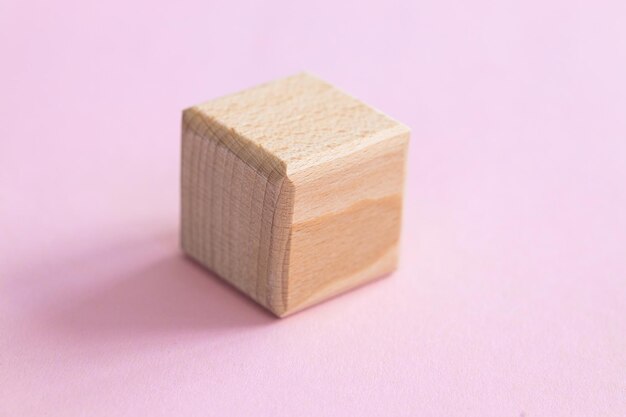 Cubo di forme geometriche in legno isolato su un rosa