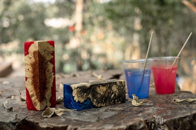 Cubo di legno di radica di resina epossidica colata su sfondo di un vecchio tavolo artistico