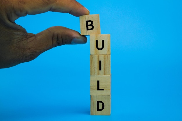 cubo di legno verticale con la parola build. il concetto di costruire o realizzare un edificio