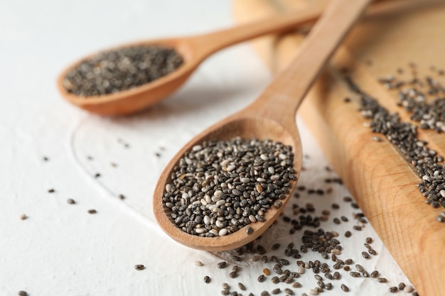 Cucchiai di legno con il chia e bordo su bianco