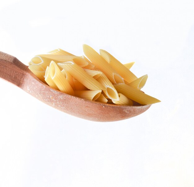 Cucchiaio di legno con pasta isolata su bianco.