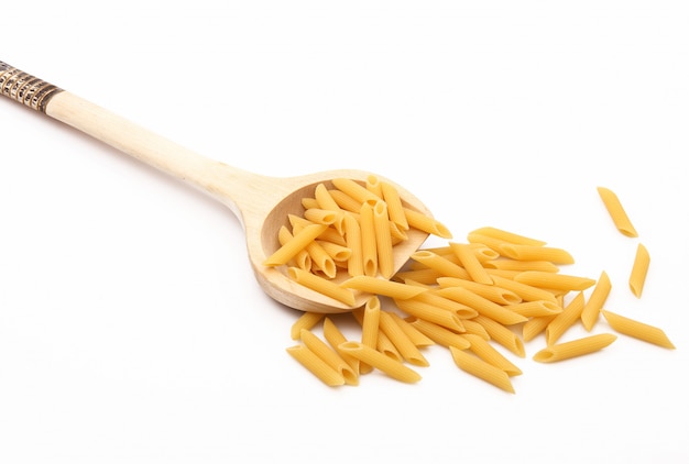 Cucchiaio di legno con pasta italiana su bianco