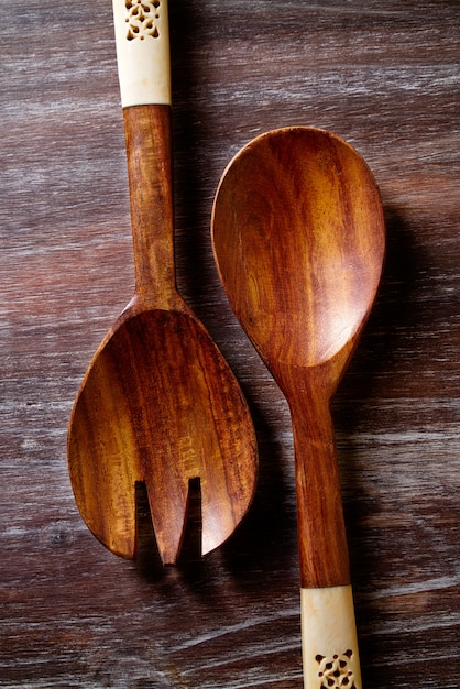 cucchiaio di legno e forchetta sul bordo di legno