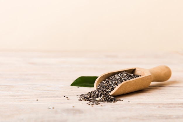 Cucchiaio di legno e semi di chia su sfondo colorato vista dall'alto Salvia hispanica sana Superfood sano