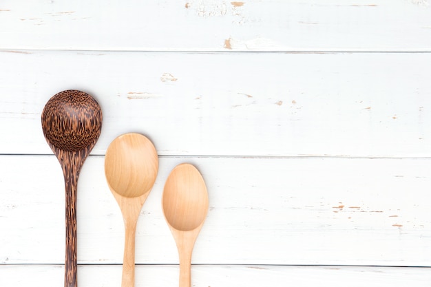 Cucchiaio di legno su fondo di legno bianco