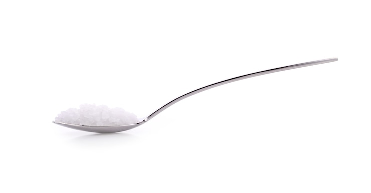 Foto cucchiaio di sale su bianco