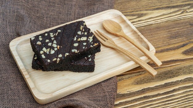 Cucchiaio e forchetta della torta dei brownies su una tavola di legno