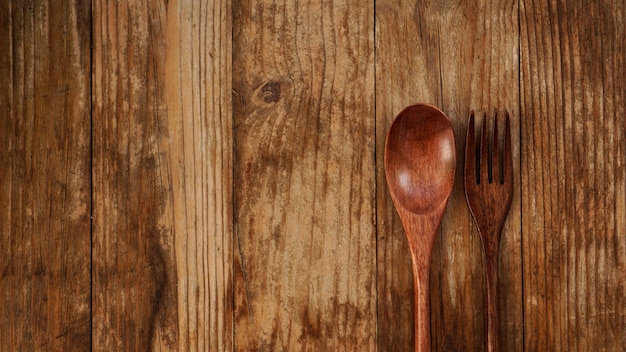 Cucchiaio e forchetta di legno su fondo di legno. Elettrodomestici in legno in stile asiatico. Copia spazio