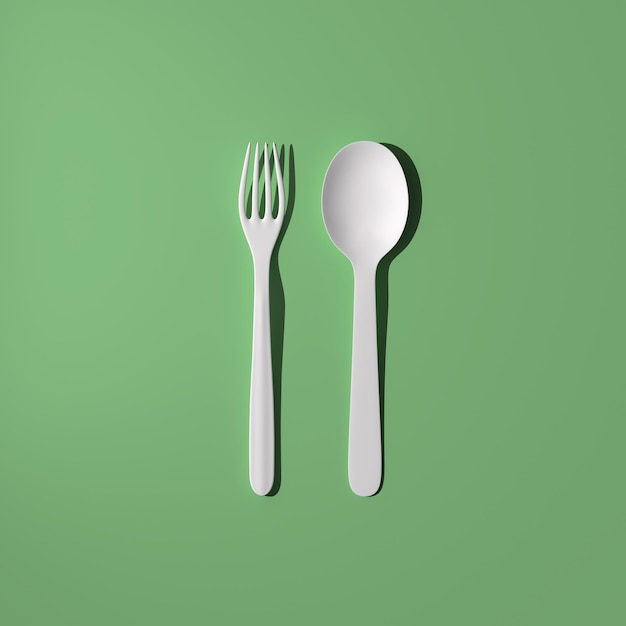 Cucchiaio e forchetta su uno sfondo verde