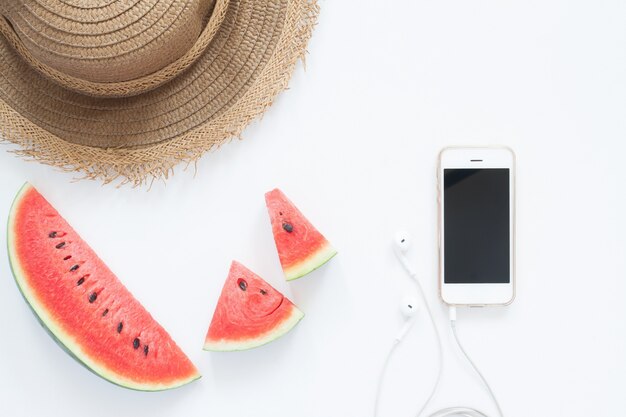 Cucchiaio fresco con smartphone e cappello, concetto di estate piana giaceva su sfondo bianco