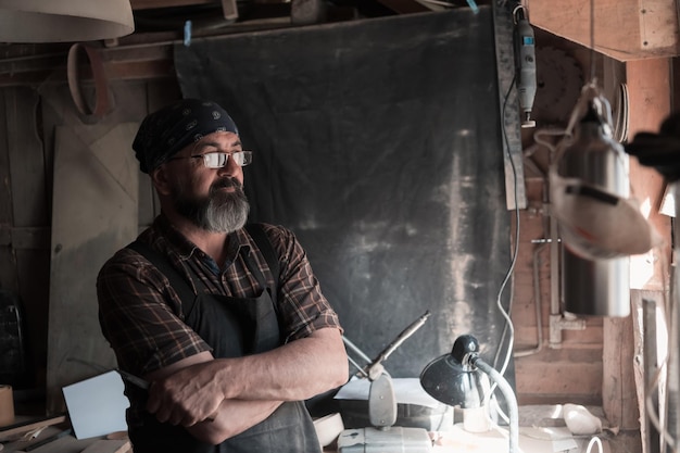 Cucchiaio maestro artigiano nella sua bottega con prodotti e strumenti in legno fatti a mano. Foto di alta qualità