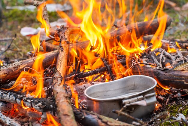 Cucina al falò durante il viaggio di trekking. Cucinare in una bombetta sul fuoco in natura. Archivio fotografico