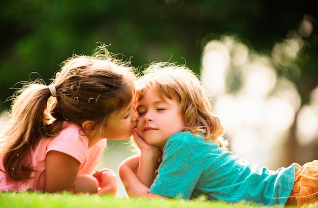 Cucina amore piccola ragazza baciare ragazzo all'aperto nel parco bambini relazioni