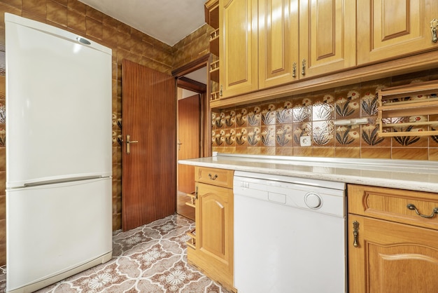 Cucina arredata con mobili in legno in stile castigliano e suggestive piastrelle vintage su pavimenti e pareti