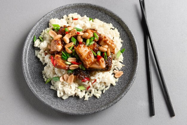 Cucina asiatica pollo kung pao piatto con riso cibo asiatico su sfondo grigio vista dall'alto