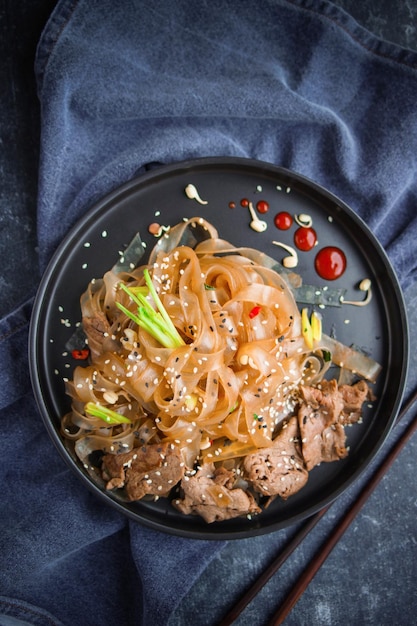 Cucina asiatica, tagliatelle di manzo asiatiche piccanti su oscurità