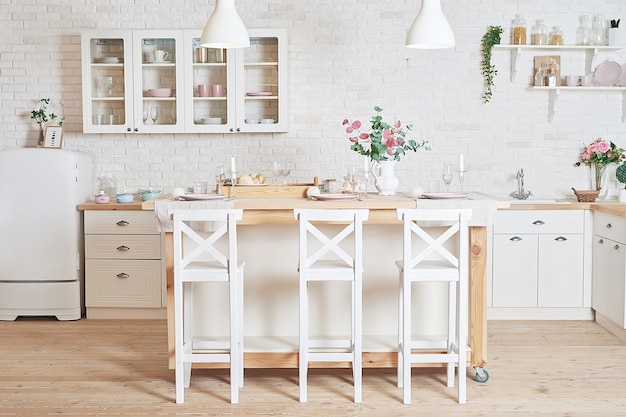 Cucina bianca in stile loft interno. Utensili da cucina e mensole.