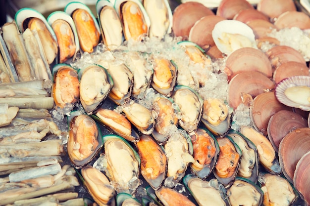 cucina, cucina asiatica, vendita e concetto di cibo - ostriche o frutti di mare refrigerati su ghiaccio al mercato di strada