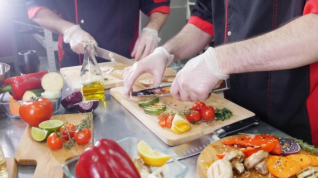 Cucina del ristorante due uomini che lavorano per servire un'insalata con verdure fritte