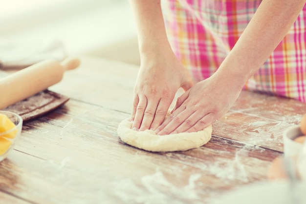 Cucina e concetto di casa - primo piano delle mani femminili che impastano la pasta a casa