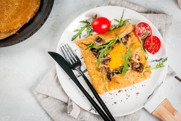 Cucina francese Colazione pranzo spuntini Cibo vegano Piatto tradizionale galette sarrasin Crepes con uova formaggio funghi fritti foglie di rucola e pomodori