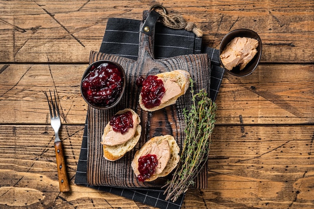 Cucina francese Foie gras toast patè di fegato d'oca e marmellata di mirtilli rossi sullo sfondo di legno Vista dall'alto