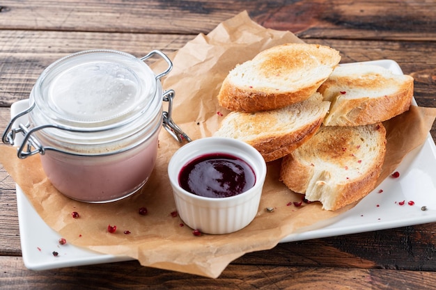 Cucina francese Foie gras toast patè di fegato d'oca e marmellata di mirtilli rossi sullo sfondo di legno