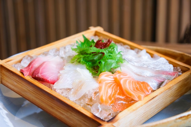 Cucina giapponese insalata di sashimi di salmone e pesce crudo su ghiaccio servita su vassoio di legno nel ristorante giapponese /