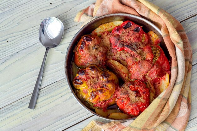 Cucina greca Peperoni stufati con riso e carne macinata su un primo piano di un tavolo di legno