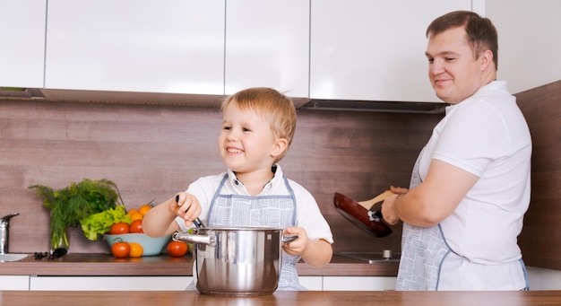 Cucina in famiglia in famiglia papà con figlio cucinare la cena per la mamma divertirsi