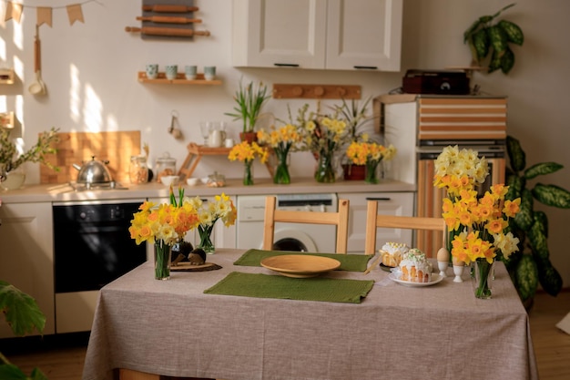 Cucina interna della casa di buona pasqua con i narcisi dei fiori freschi e le torte di Pasqua