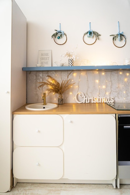 Cucina interna grigio chiaro e decorazioni natalizie rosse Preparare il pranzo a casa sul concetto di cucina Concentrarsi sull'albero