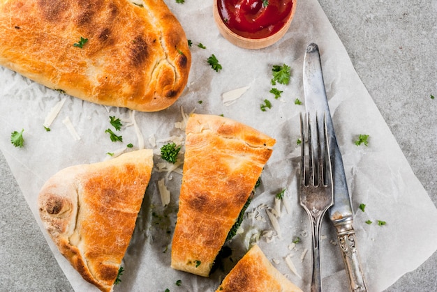 Cucina italiana, pizza chiusa calzone con spinaci e formaggio