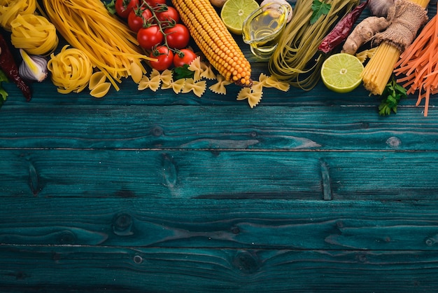 Cucina Italiana, Verdure Fresche. Set di pasta, tagliatelle, spaghetti. Su uno sfondo di legno blu. Vista dall'alto. Copia spazio.